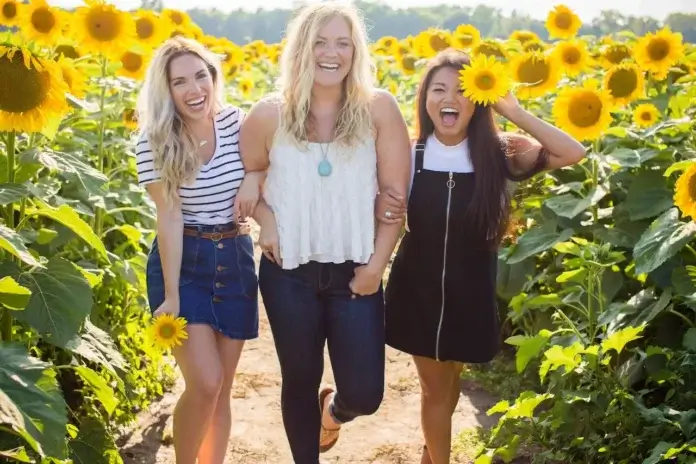 body positivity, three female friends in a sunflower field